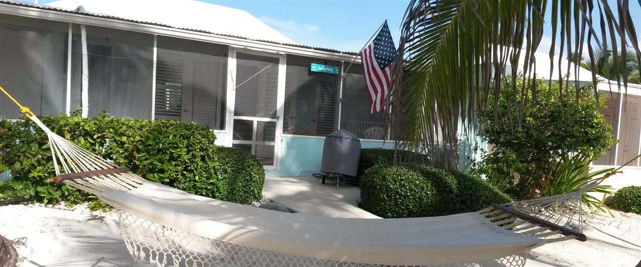 Hammock and American flag outside the cottage beside the SeaRendipity welcome sign